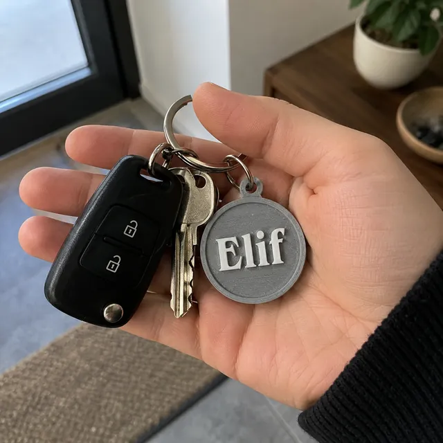 Gri isimli yuvarlak anahtarlık elde